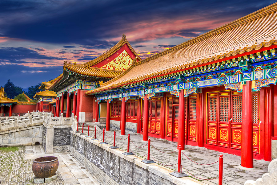 Dawny pałac cesarski w Pekinie. Widok z perspektywy od boku. Czerwone ściany i żółty dach. Wiele drobnych i kolorowych ornamentów.