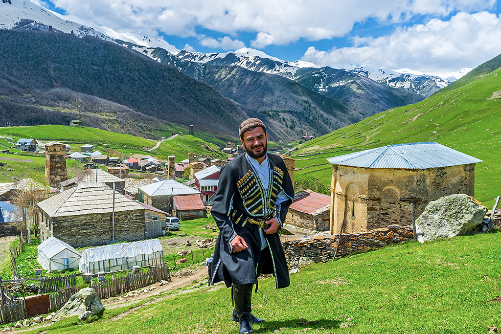 Gruzin w tradycyjnym gruzińskim stroju na tle gór Kaukazu